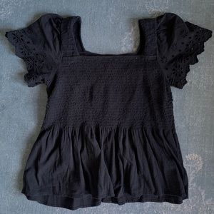 Madewell black top with eyelit detail sleeves.